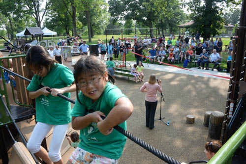 Children climb on the play structures during the grand opening ceremony for the universally accessible play area.
