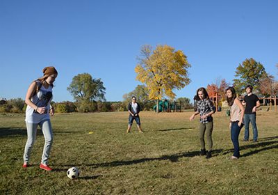Five teens playing soccer.