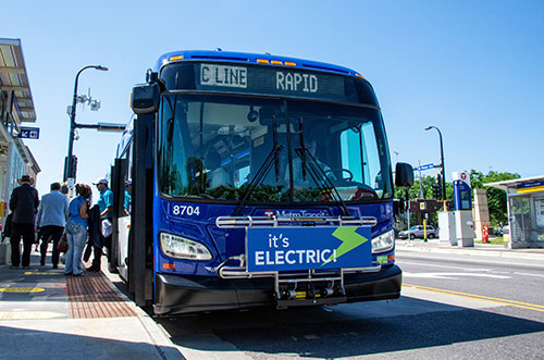 People boarding an electric bus.