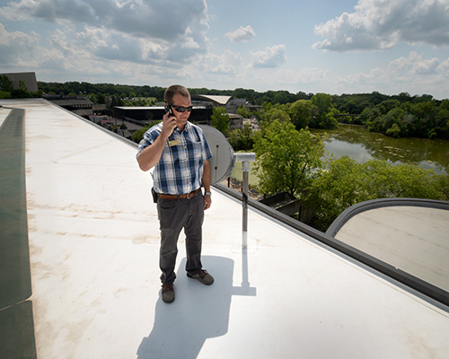 Derik Otten, director of project services at the Minnesota Zoo, on the roof of the Tropical Building, with main pond in the background.