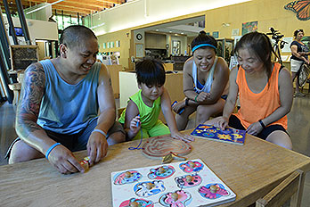 Four people working on a puzzle in a park visitor center.