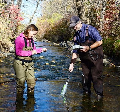 Taking water samples from a stream.