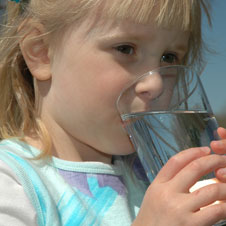 photo of a young girl drinking a glass of water