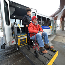 Driver assists man in wheelchair on to bus