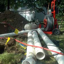 photo of long pipes laid out in a pile on lawn