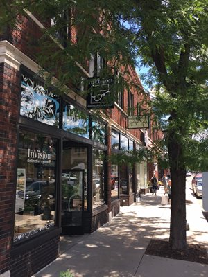 Buildings create a sense of enclosure, and trees provide shade along the sidewalk for pedestrians.