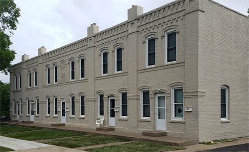 A two-story light-colored brick building.