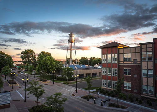 Sun setting on a downtown with a water tower and buildings.