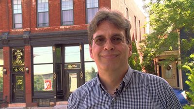 Rich Holst in front of an apartment building.