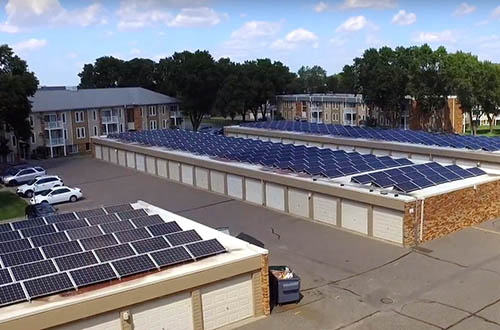 Solar panels on the roofs of residential parking structures.