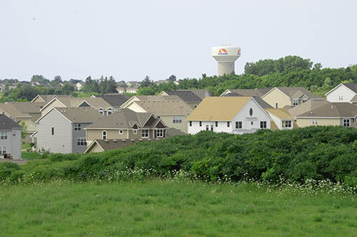 Tall single-family houses with trees.