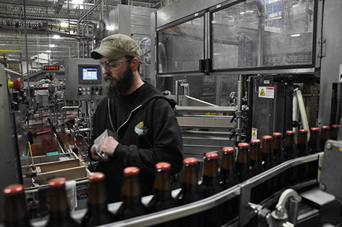 A worker in a beer manufacturing building.