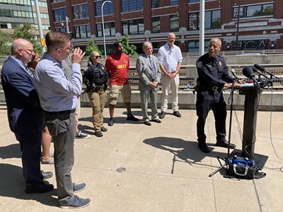 Metro Transit Police Chief speaking at dais, flanked by eight other people.