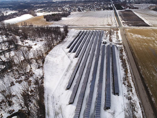 Overhead view of 11 rows of solar panels in winter.