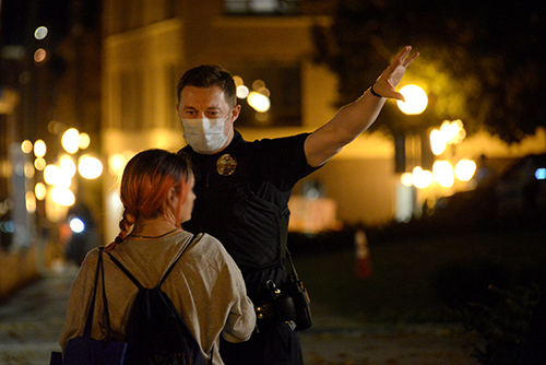 A Homeless Action Team member in a facemask giving directions.