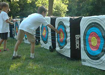 Child pulling arrow out of target.