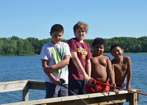 A group of friends fishes from a pier at Lake Elmo Regional Park Reserve.