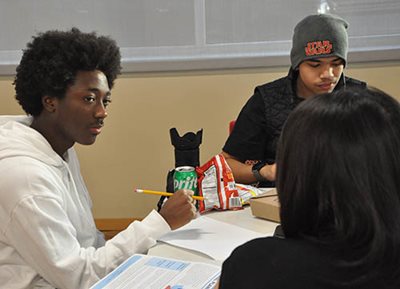 Young people converse with each other at a community meeting.