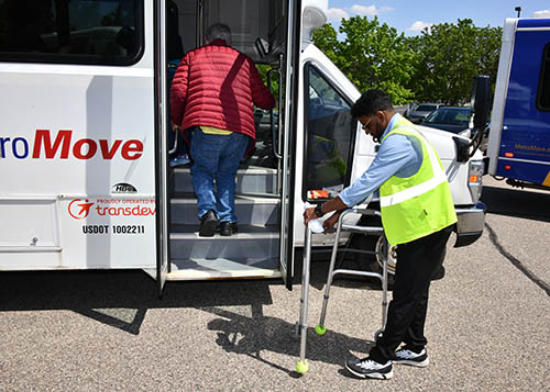 Passenger boards Metro Move bus as driver stands by.