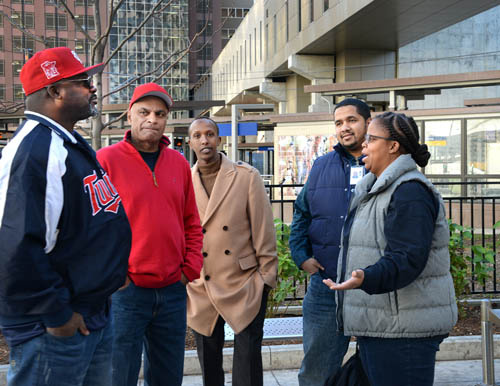 St. Paul City Ambassadors in the juvenile diversion program talk with Officer Blakey, right, in downtown Saint Paul.