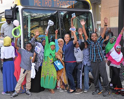 About a dozen students posing in front of a Metro Transit bus.