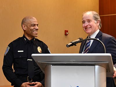 Two people smiling at a podium.