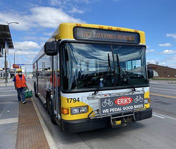 A bus with a Face Coverings Required sign on the front.