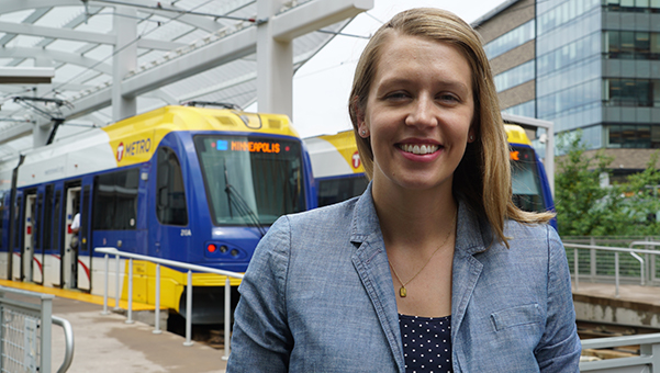 Joan Hollick, with two light rail trains in the background
