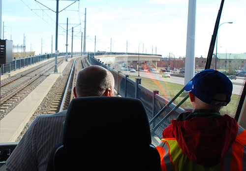 Karlis helps pilot an out-of-service LRT train on the Blue Line over Hiawatha Avenue near Lake Street.