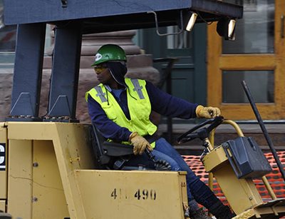 A worker looking backwards to drive in reverse.