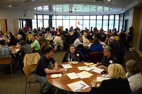 Dozens of participants gathered at tables to discuss possible Metro Mobility fare increases and other issues. Dozens of participants at tables for Metro Mobility 2017 meeting.