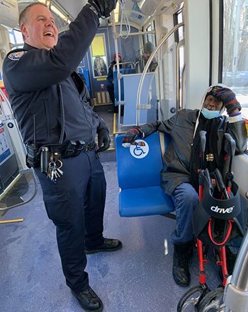 A Metro Transit Police officer chats with a light rail passenger.