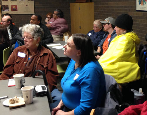 Metro Mobility customers listen as facilitators share highlights from table conversations.