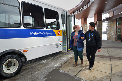 A rider and driver next to a Metro Mobility vehicle.