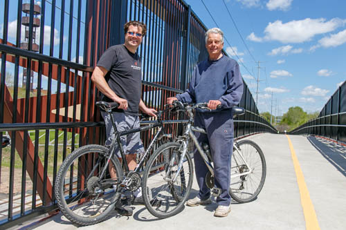 Cyclists stop on the Luce Line Trail pedestrian/bicycle bridge over County Rd. 61 in Plymouth, a project funded in a previous regional solicitation.