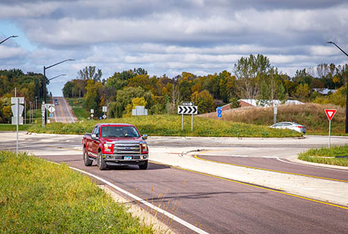 A red truck driving around a roundabout.