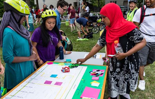 Three people at a table with post-it notes and markers.