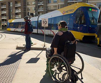 A rider in a wheelchair near a Green Line train.