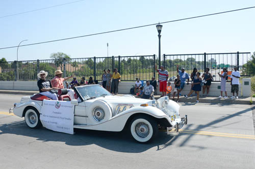 The Rondo Days parade crosses over I-94 on Victoria Street, in the heart of the eastern portion of the Rethinking I-94 project. Pictured in the back of the car are Rondo Days founders Marvin Anderson and Floyd Smaller.