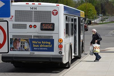 A man with shopping bags boards a Metro Transit bus.