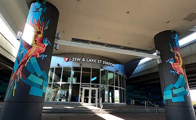 Entry pillars to a transit station are painted with colorful birds.