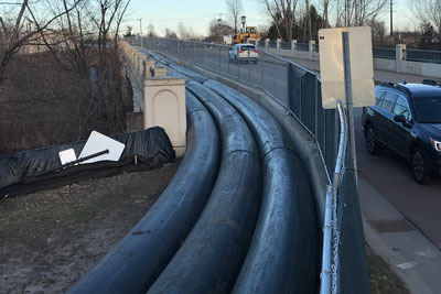 Three large pipes on a bridge.