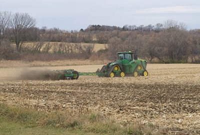A tractor with a disc attachment adding biosolids into the field.