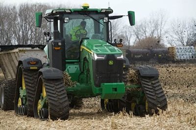 A farmer on a tractor spreads biosolids on a field.
