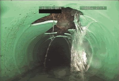 Groundwater can flow into sewer pipes when they are broken or have cracks in the joints. Water leaks into pipe at a broken section.