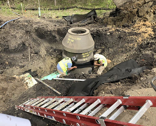 Looking down at two people working in a hole.