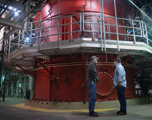 Wastewater operators stand near the base of one of the Metro Plant’s three solids incinerators