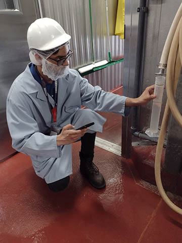 An intern checks equipment on the Kemps factory floor.