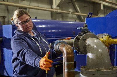 A plant operator adjusts machinery in the solids management building at the Metro Plant in St. Paul.