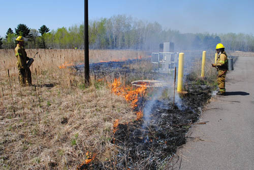 Crews from the contractor Applied Ecological Services work carefully along fence lines, utility equipment and driveways to contain the prescribed burn within specified areas of a reclaimed water discharge site in the City of East Bethel.
